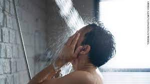 A man washing his face in the showers